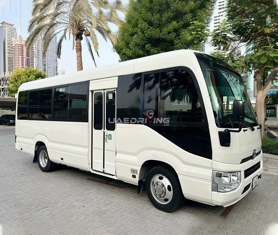 Front view of a white Toyota Coaster 22 Seater bus showcasing its impressive size and elegant features